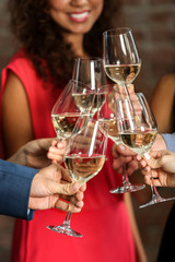 People toasting with glasses of white wine, closeup