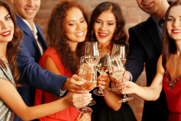 People toasting with glasses of white wine