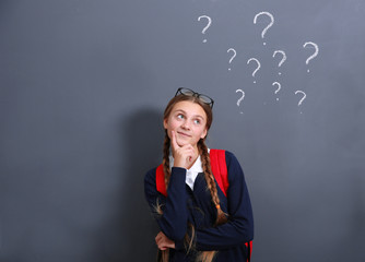 Teenage girl standing near school blackboard