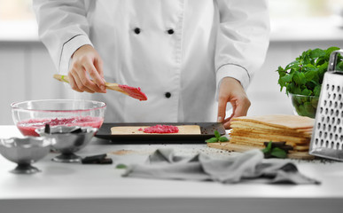 Cooking concept. Professional confectioner making delicious cake with fruit cream, closeup