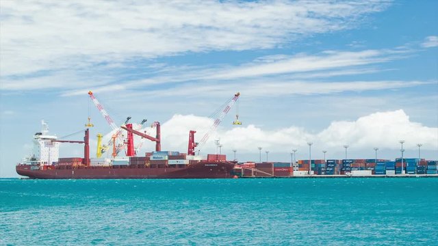Cargo Container Freight Ship Docked in Tropical Waters of Papeete Tahiti in French Polynesia on a Sunny Day with Turquoise Water