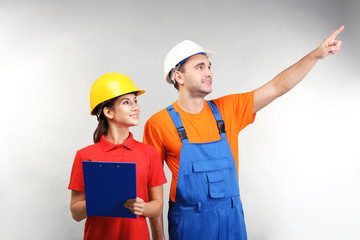 Warehouse workers with clipboard discussing something, on light background