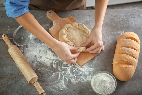 Woman making bread on kitchen table