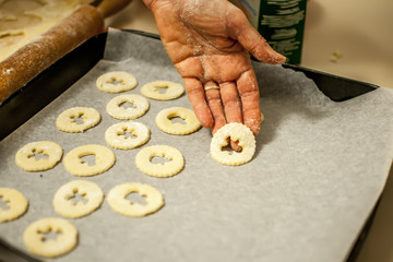 preparare i biscotti di natale con farina uova zucchero e marmellata con il mattarello