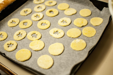 Obraz na płótnie Canvas preparare i biscotti di natale con farina uova zucchero e marmellata con il mattarello