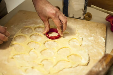 preparare i biscotti di natale con farina uova zucchero e marmellata con il mattarello