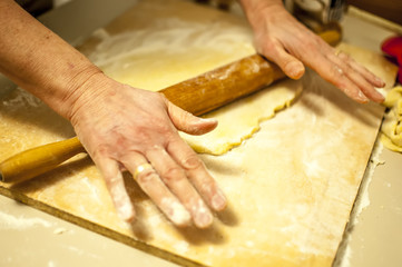 impastare a mano i biscotti di natale con farina zucchero uova e mattarello