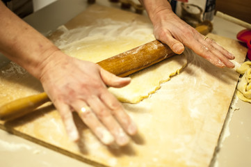 impastare a mano i biscotti di natale con farina zucchero uova e mattarello