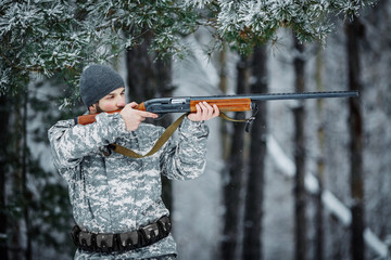 Male hunter in camouflage looking for his target or prey .Winter
