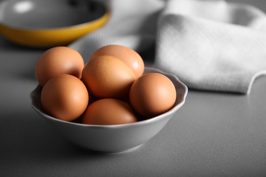 Raw eggs in bowl on kitchen table