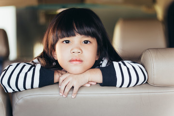 depressed Asian chinese child. Little girl showing her unhappy face in car