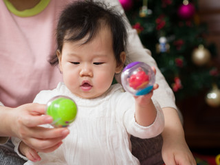 Fototapeta na wymiar Asian baby girl playing toy with Mom