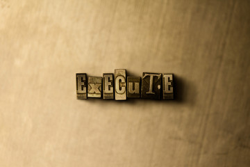 EXECUTE - close-up of grungy vintage typeset word on metal backdrop. Royalty free stock - 3D rendered stock image.  Can be used for online banner ads and direct mail.