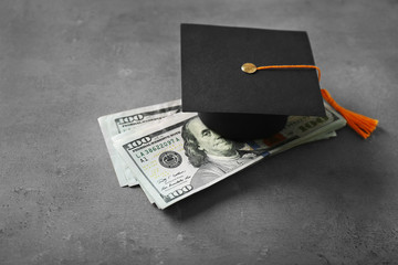 Graduation hat and dollar banknotes on table. Tuition fees concept - obrazy, fototapety, plakaty
