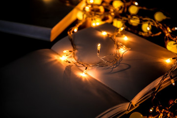 Close up view of open book and beautiful garland on table