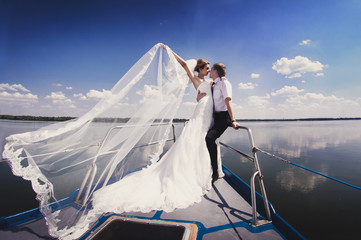 Just married couple on yacht. Happy bride and groom on their wed