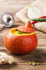 Pumpkin soup served inside of a hollowed pumpkin