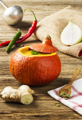 Pumpkin soup served inside of a hollowed pumpkin