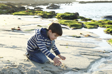 kid playing with sand and water in the beach