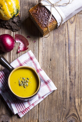 Creamy pumpkin soup with seeds in a ceramic rustic bowl