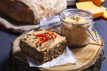 A slice of grainy bread with homemade pumpkin puree, on a wood