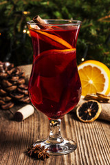 Mulled wine with cinnamon with cone and dried oranges in the bac