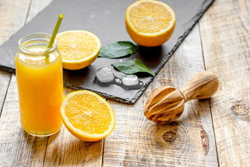 freshly squeezed orange juice in glass bottle on wooden background
