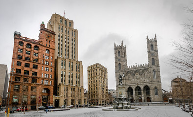 Fototapeta na wymiar Basilica of Notre-Dame of Montreal and Place d'Armes on snow - Montreal, Quebec, Canada