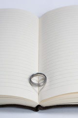 Wedding Ring Band on Book with Heart Shadow Close Up Distant Vie
