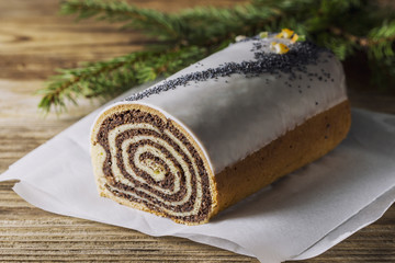 Poppy seeds cake on the wooden table with branch of pine