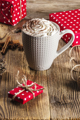 Christmas hot cocoa on a wooden table surrounded by  presents