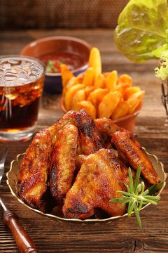 Chicken hot wings with baked potatoes and barbecue sauce