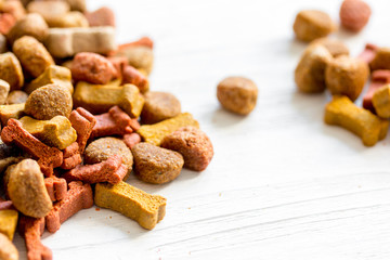 dry dog food in bulk on wooden background close up