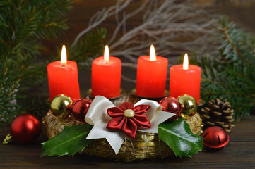Advent wreath with four burning candles on it. Christmas decoration