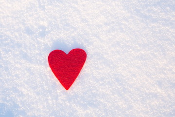 Red felt heart on snow, Valentine's Day. Copy space for text. Valentines day, love concept. White background