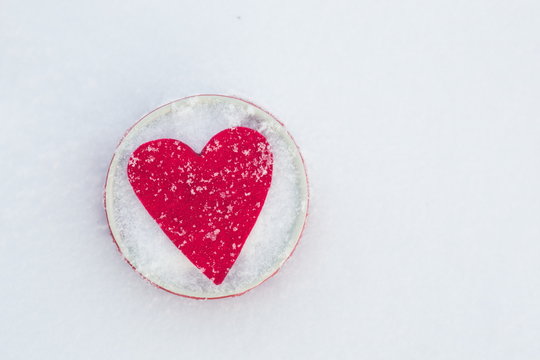 Red felt heart in a bowl on snow, Valentine's Day. Copy space for text. Snowflakes on heart. Valentines day, love concept. White background