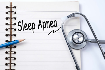 Stethoscope on notebook and pencil with sleep apnea words as med