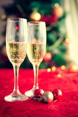 Two glasses of champagne near beautiful christmas tree