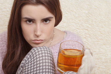 sad girl in gloves with cup of tea