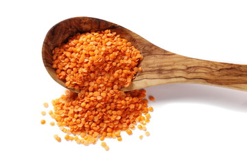 red lentils in wooden spoon isolated on white