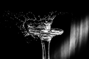 Abstract black and white background with a splash from falling drop on glass in the shape of a crown