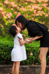 Obraz premium Mother and Daughter kissing at the nature field.