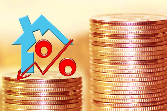 The symbol of the real estate and of percent on the background of money . The concept of changes in the value of the property