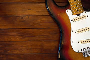 Vintage guitar without strings on background with dark wooden desk