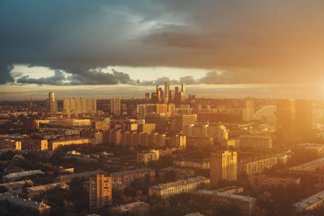 View from top of cityscape, residential buildings, park areas, group of "Moscow City" skyscrapers in distance, horizon, morning and sunrise, Moscow, Russia