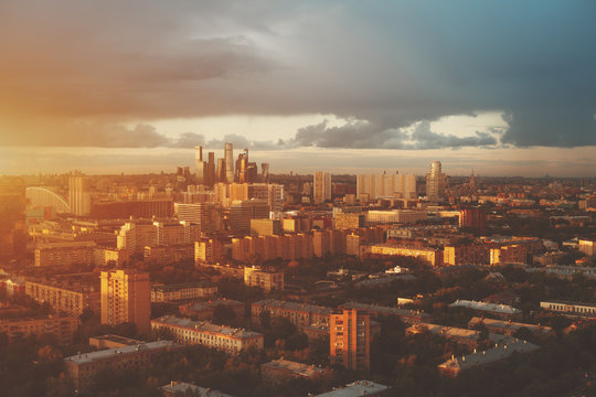 View from top of cityscape, residential buildings, park areas, group of "Moscow City" skyscrapers in distance, horizon, morning and sunrise, Moscow, Russia