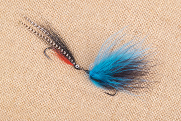 Arrangement of Fishing Flies of Various Sizes on Burlap Background