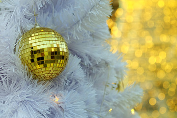 Golden Christmas ball items on white pie and yellow bokeh form LED lighting background. have some space for write wording to Merry Christmas and happy new year