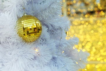 Golden Christmas ball items on white pie and yellow bokeh form LED lighting background. have some space for write wording to Merry Christmas and happy new year