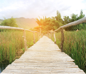 bamboo bridge walkway over the lake with burst sunrise light ,dr